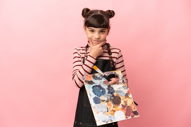 Little artist girl holding a palette isolated