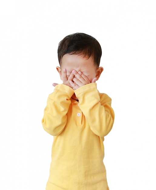 Little Asian boy covering his eyes with hands isolated on white background