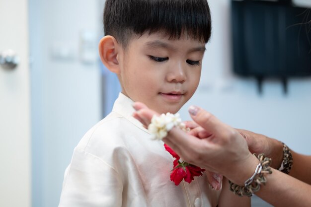 Foto un ragazzino asiatico regala una ghirlanda di gelsomino alla madre in occasione della festa nazionale della madre in thailandia