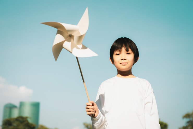 Photo 風車または風力タービンのモックアップモデルを握っている小さなアジア人少年gyre