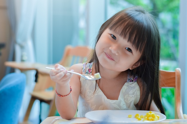 Little asian child girl having breakfast at the morning 