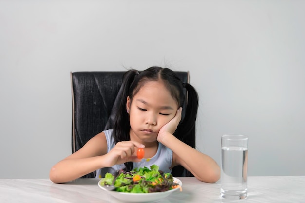 건강한 채소를 먹기를 거부하는 아시안 소녀 영양 어린이를 위한 건강한 식습관 개념 어린이들은 채소를 먹는 것을 좋아하지 않습니다.