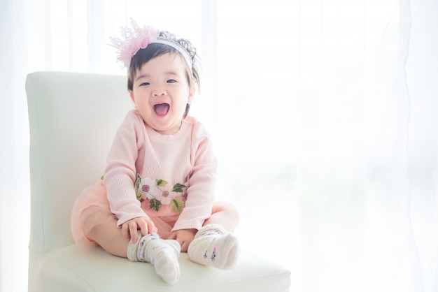 Little asian cute girl sitting and smiles on the chair