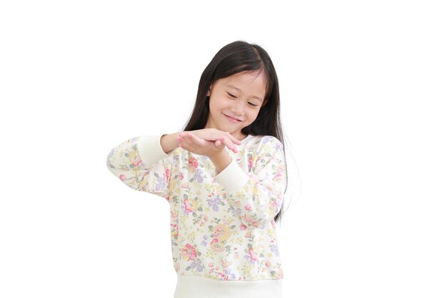 Little asian girl applying lotion in hands over white background