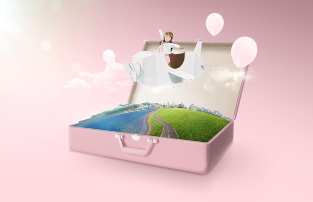 Little asian girl enjoy with fantasy cardboard plane fly and\
floating in an open retro vintage suitcase isolated on pink\
background . travel and vacation concept.