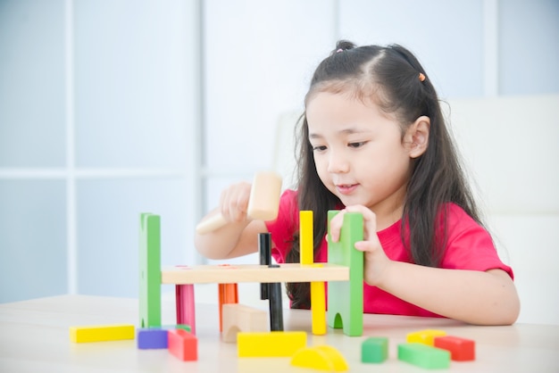 写真 家でおもちゃを遊んでいる小さなアジアの女の子