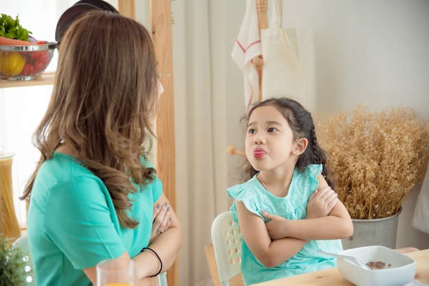 Little asian girl refuse to having breakfast with her mother