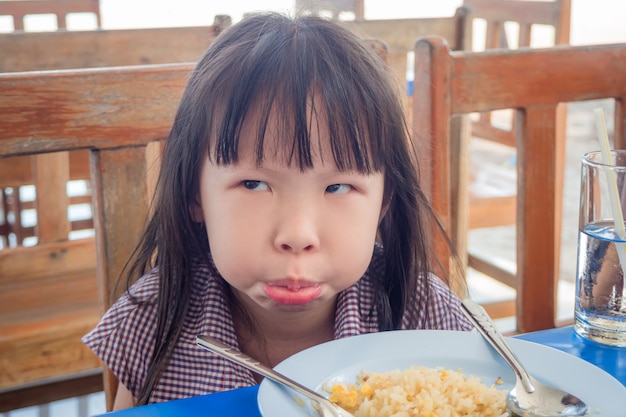 점심에 볶음밥을 거부하는 작은 아시아 소녀