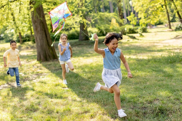 Little Asian girl running happily with a kite in the park