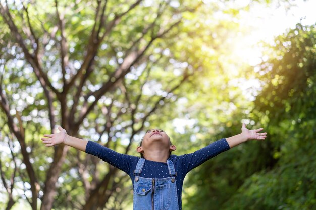 Little asian girl standing and open her arms in the garden, Freedom idea concept