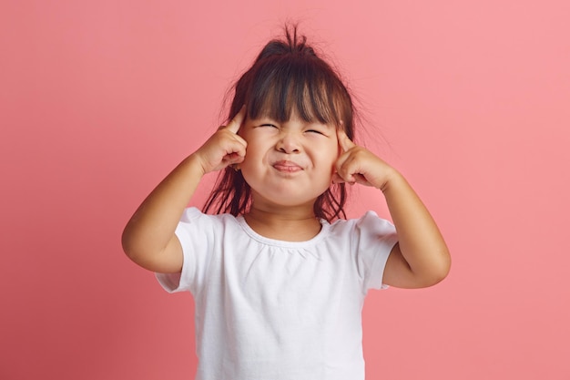 little Asian girl of three years squinting struggling to concentrate remember important information