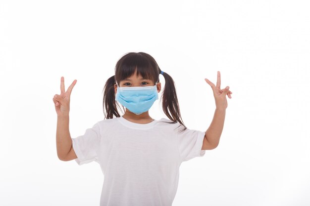 Little asian girl wearing mask holding hands up with two fingers