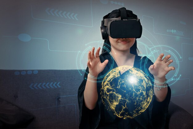 Little asian girl wearing virtual reality goggles standing against network hologram Future technology concept