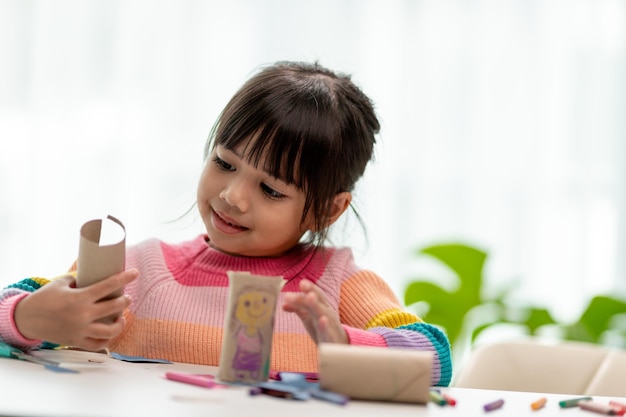 Little Asian girls are making tissue paper core binoculars Reuse waste products Idea custom made toy Soft focus