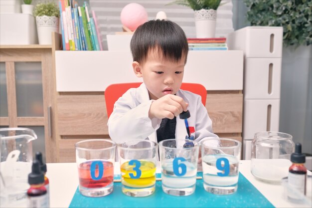 科学を勉強している小さなアジアの幼稚園の子供