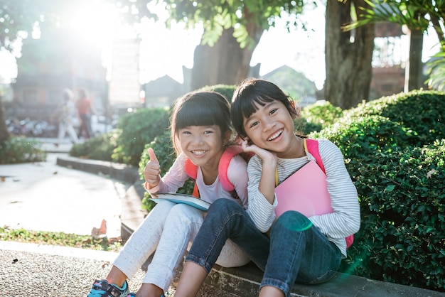 一緒に公園に座っている小さなアジアの学生