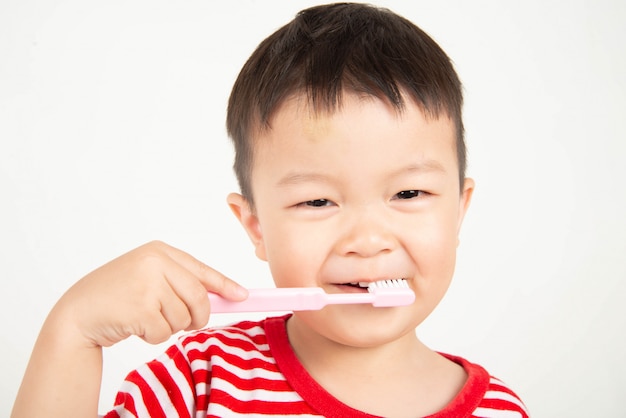 Little Asian toddler boy brushing teeth 