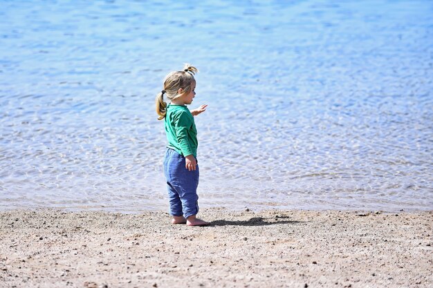 Piccolo neonato alla spiaggia dell'infanzia e della felicità all'aperto di vacanze estive dell'oceano o del mare