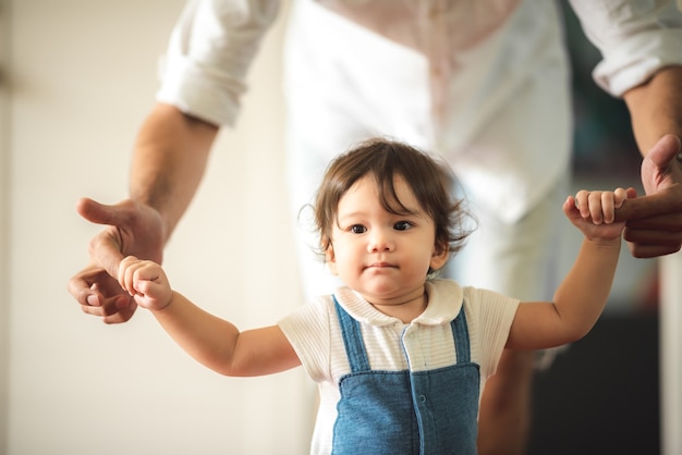 Little baby boy crawling on the floor, cute child, beautiful son, holding father's hand and walking. smiling infant, family happy time concept. lovely and cute.