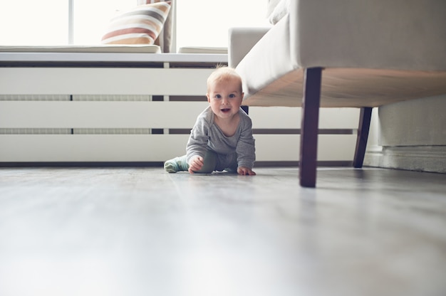 Little baby boy crawling on floor at home