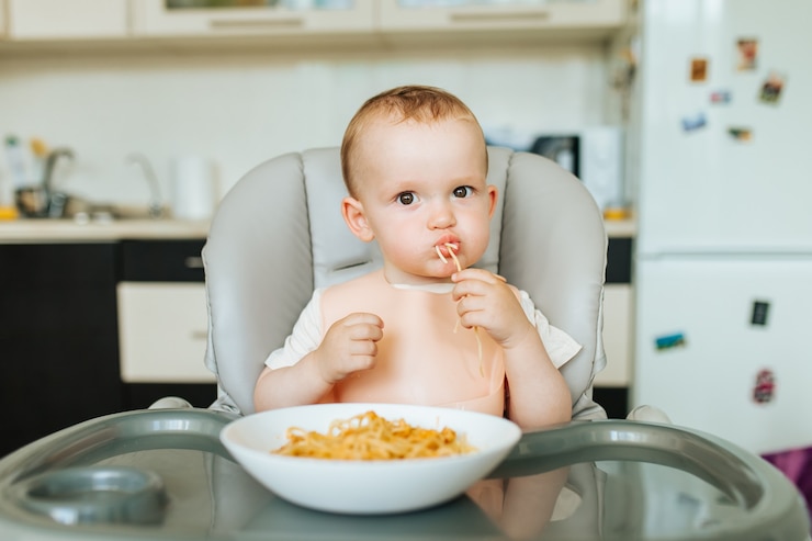 Photo little baby boy eating spaghetti dinner and making a mess nice child eating healthy organic and vega...