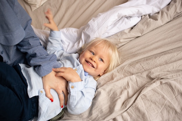 Фото Маленький мальчик на кровати с родителями весело