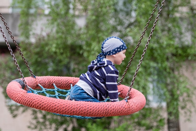 Little baby boy riding on a swing