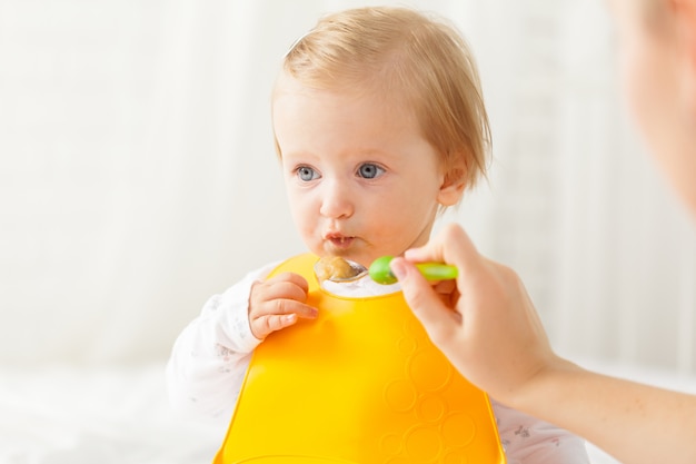 Piccolo bambino che si alimenta con un cucchiaio