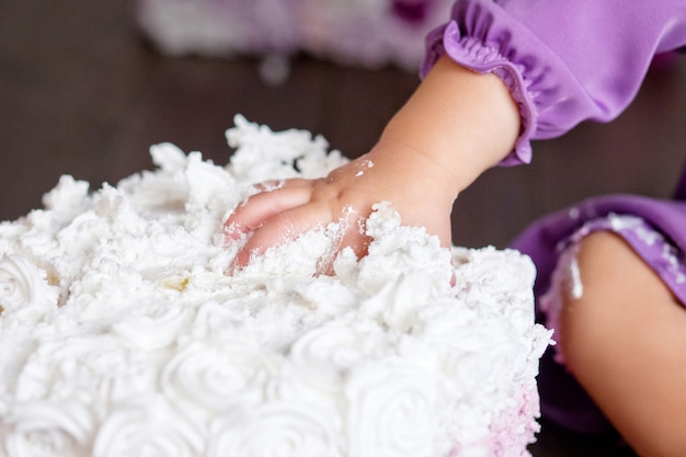 Piccola neonata che celebra il suo primo compleanno con una festa di torta smash