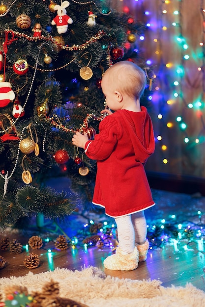 Little baby girl decorates the Christmas tree