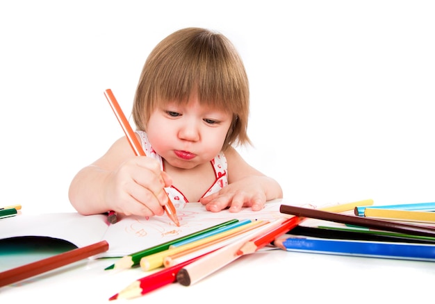 Little baby girl draws pencil on a white background