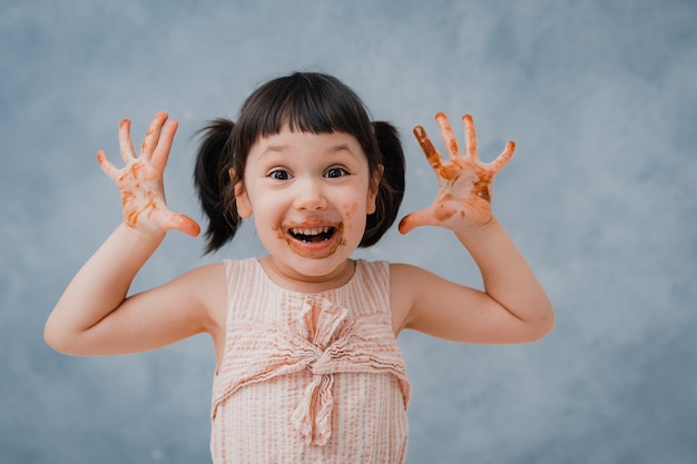 Little baby girl eats chocolate and licks her finger