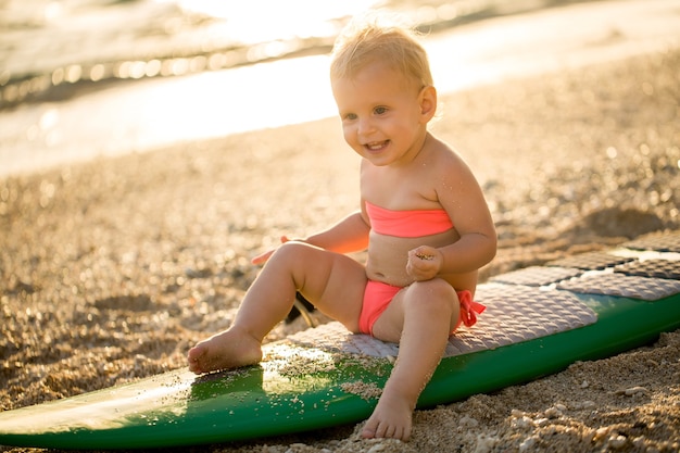 La piccola neonata sta imparando il surf