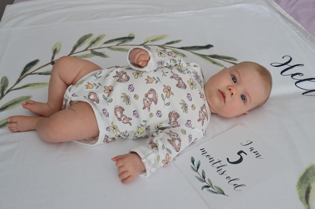 little baby girl lies on a sheet 5 months old play laughs