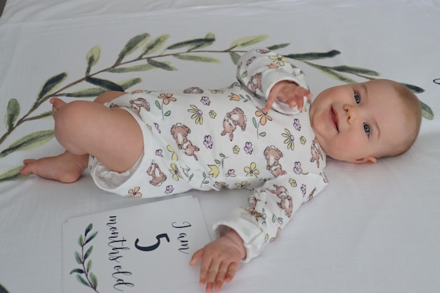 little baby girl lies on a sheet 5 months old