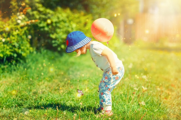 Little baby girl on the magic meadow with balloon