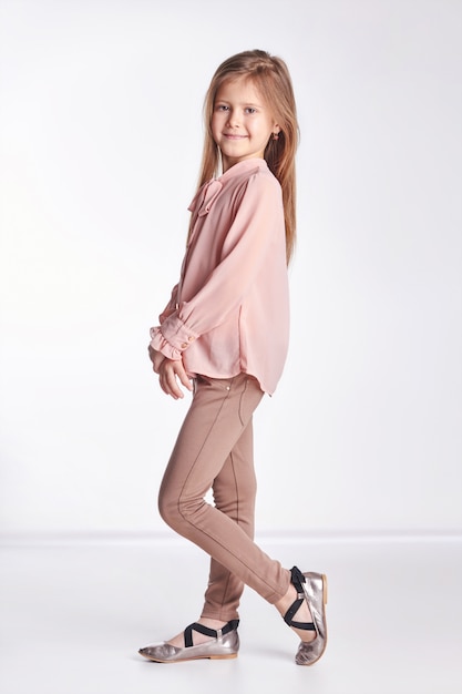 Little baby girl in pink blouse and pants posing