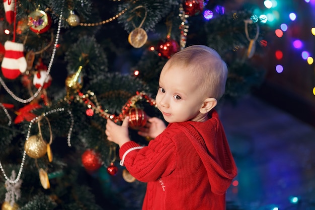 Little baby girl waiting for a miracle in Christmas decorations