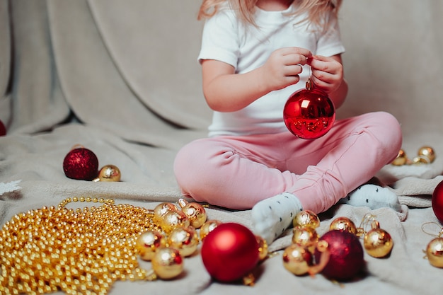 Photo little baby girl with christmas ornaments around.