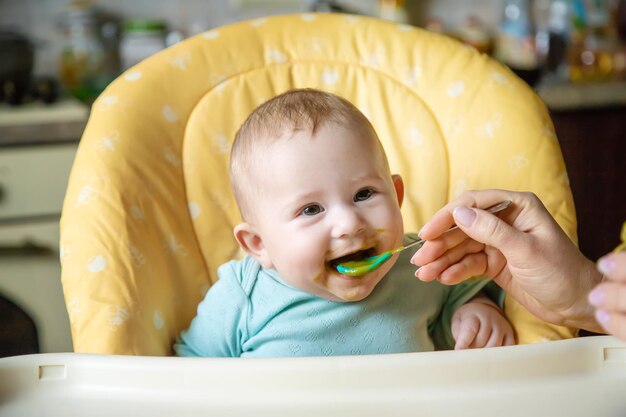 Little baby is eating broccoli vegetable puree Selective focus