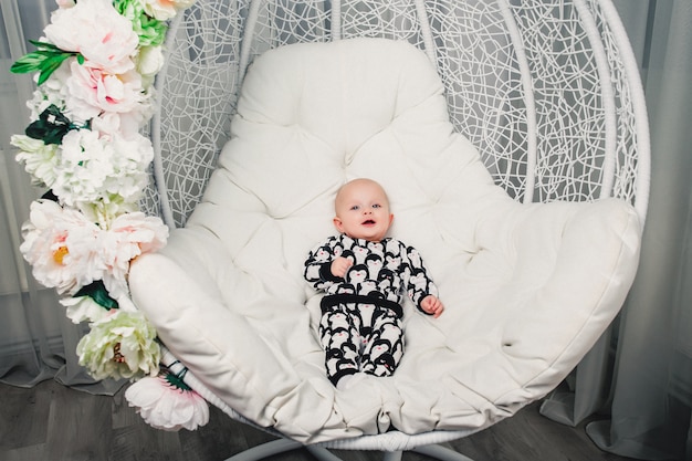 Little baby lying on a round swing and smiling