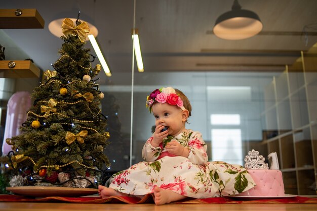 Little baby near christmas tree before new year party