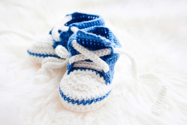 Little baby shoes. Handknitted first sneakers for newborn boy or girl. Crochet handmade bootees