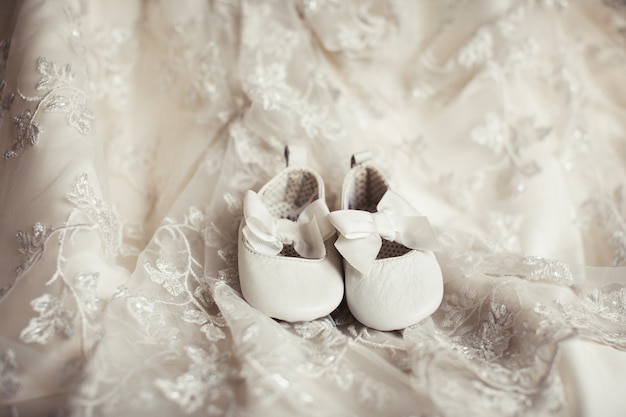 Little baby shoes on lace fabric