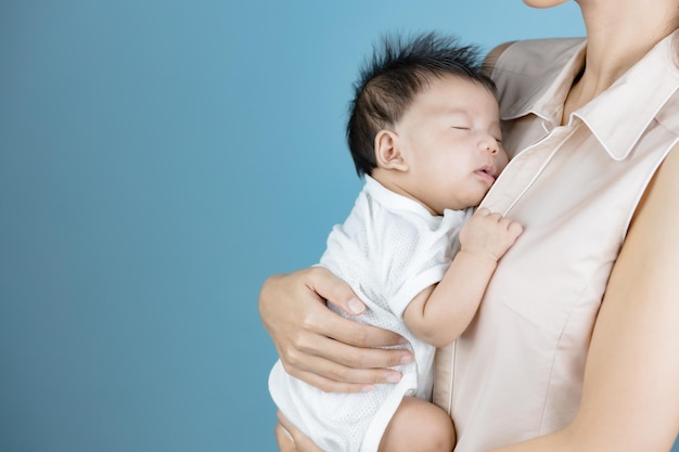 Little baby sleeping on the chest of his mother