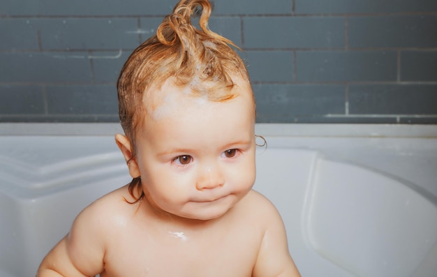 Маленький ребенок принимает ванну крупным планом лицо портрет улыбающегося мальчика здравоохранение и детская гигиена