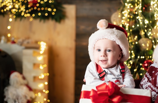 Little baby wearing Santa hat Portrait of funny baby in Christmas hat New year fun