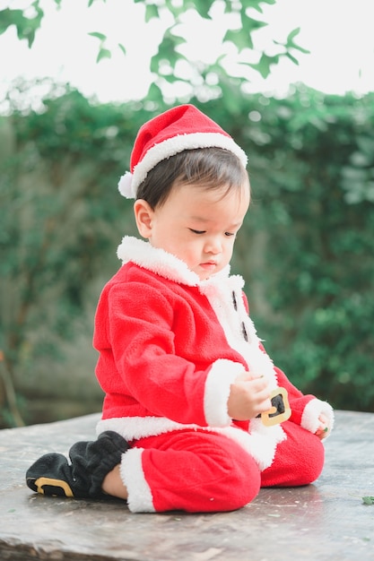 Little baby with Santa Claus outfit looking down