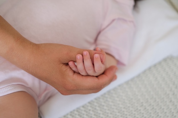 Little babys hand hold mothers finger. Happy family. Enjoy time together At home. Slow motion. Love. Sweet. Tenderness.