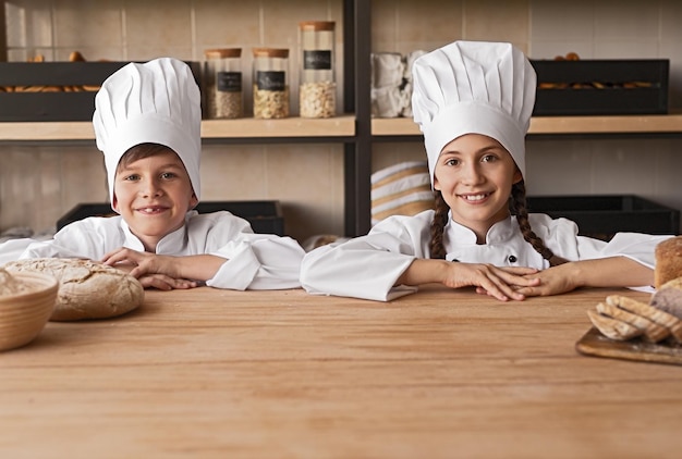 Little bakers behind counter in kitchen